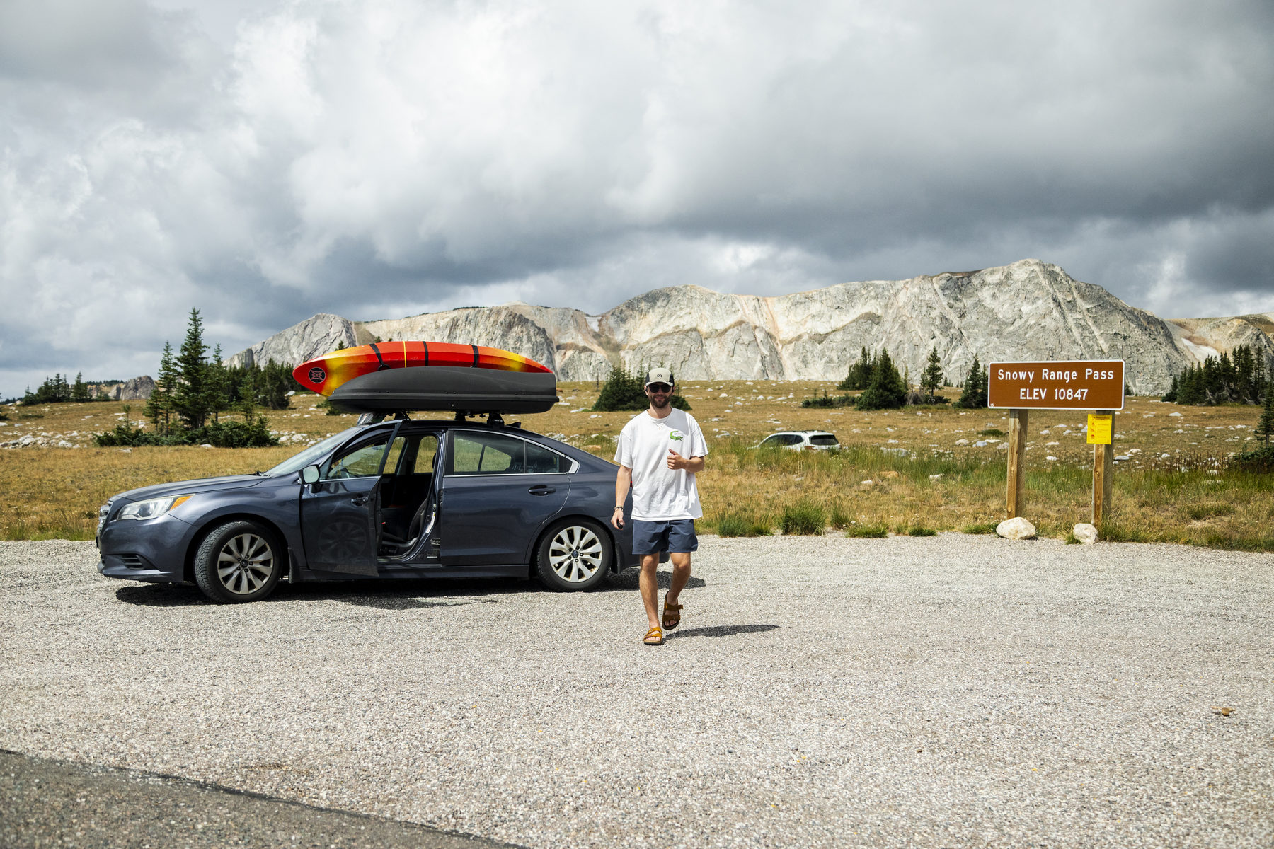 Thumbs up beside the Subaru Legacy Car Camper at Snowy Range Pass, Wyoming